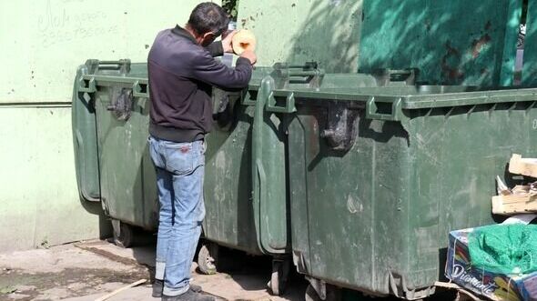Мужчина ест дыню прямо из мусорного бака - отходы с рынка выкидывают прямо в баки возле домов