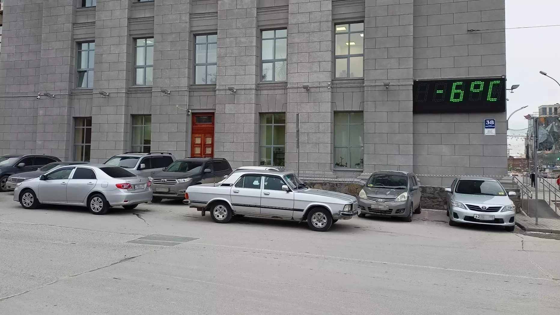 Служебные автомобили «Тойота» и «Волга» на парковке у мэрии Новосибирска